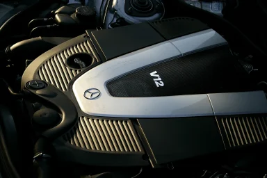 Detail eines Mercedes-Benz V12-Motors mit silberner Motorabdeckung.
