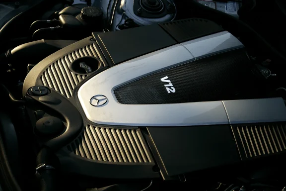 Detail eines Mercedes-Benz V12-Motors mit silberner Motorabdeckung.