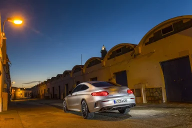 Mercedes-AMG C 63 S Coupé in Iridiumsilber Magno steht in einer ruhigen Straße bei Dämmerung.