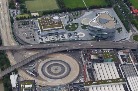 Luftaufnahme des Mercedes-Benz Museums in Stuttgart mit dem markanten Baukörper und der umliegenden Verkehrslandschaft.