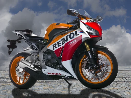 Honda CBR1000RR Fireblade Repsol Edition (2015) in der markanten Repsol-Lackierung auf einem Platz unter einem eindrucksvollen Wolkenhimmel.