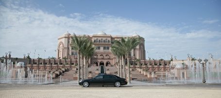 Emirates Palace in Abu Dhabi mit Fontänenanlage und Luxuslimousine.
