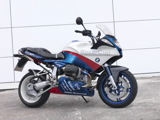 BMW R 1100 S BoxerCup in BMW Motorsportfarben vor moderner Architektur.