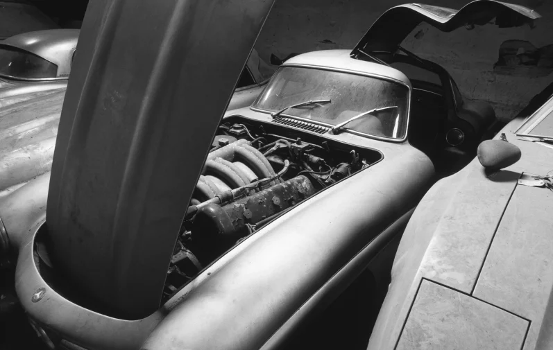 Mercedes-Benz 300 SL Alu Mercedes-Benz 300 SL „Alloy“ Gullwing von 1956 mit geöffneter Motorhaube und sichtbarem Motorraum in Schwarzweiß.