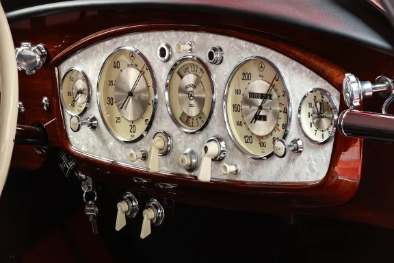 Detailaufnahme des edlen Armaturenbretts eines Mercedes-Benz 540 K mit klassischen Instrumenten, Holzverkleidung und zeitloser Eleganz.
