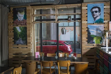 Blick aus einem Restaurant auf einen roten Mercedes-Benz CLA vor dem Gebäude.