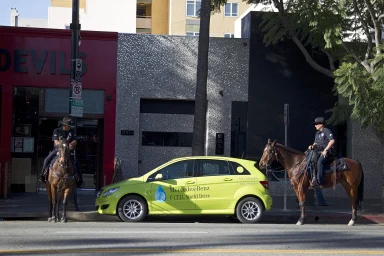 Mercedes-Benz F-CELL World Drive in Los Angeles, flankiert von zwei berittenen Polizeibeamten.