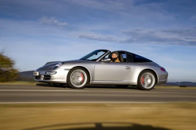 Porsche 911 Cabrio mit Targadach in dynamischer Seitenansicht auf einer Landstraße – Automobilfotografie von Dieter Rebmann.