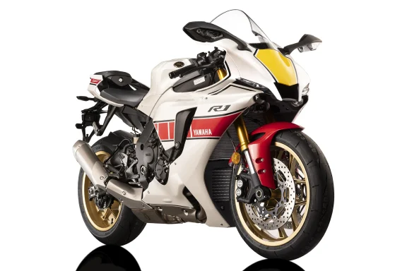 Weiße Yamaha YZF-R1 60th Anniversary Edition mit roten und gelben Akzenten im Fotostudio.
