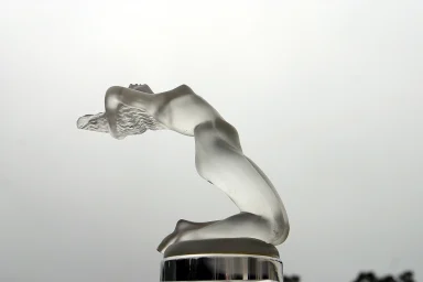 Lalique Kühlerfigur Chrysis aus satiniertem Glas auf einem Oldtimer.