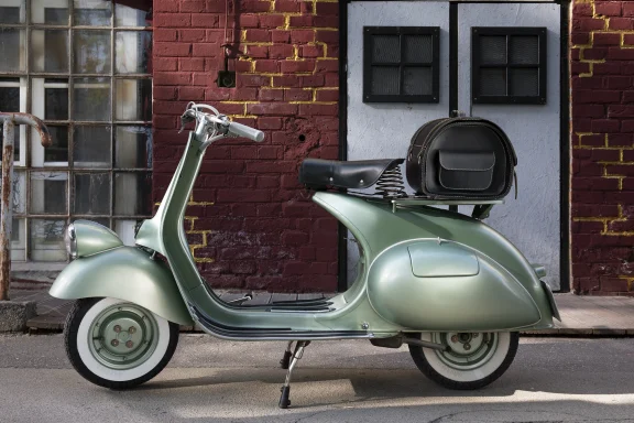 Hellgrüne Vespa VT33 Baujahr 1952 vor einer historischen Backsteinfassade.
