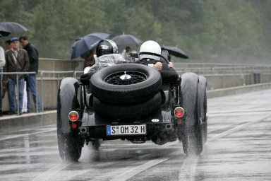 Mercedes-Benz SSK auf nasser Rennstrecke im Regen mit aufspritzendem Wasser.