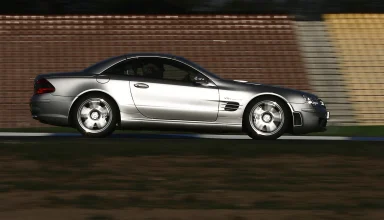 Silberner Mercedes-Benz SL 65 AMG in dynamischer Seitenansicht auf einer Rennstrecke.