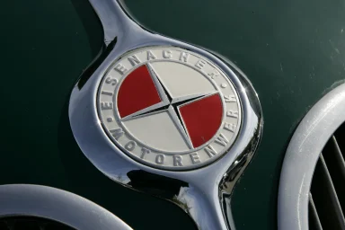 Nahaufnahme des Emblems des Eisenacher Motorenwerks an einem historischen Fahrzeug.