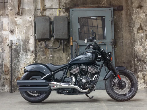 Indian Chief Bobber Dark Horse 2022 in mattschwarzer Lackierung vor rustikalem Industriehintergrund.